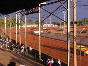 The track surface is a bright red Oklahoma clay.